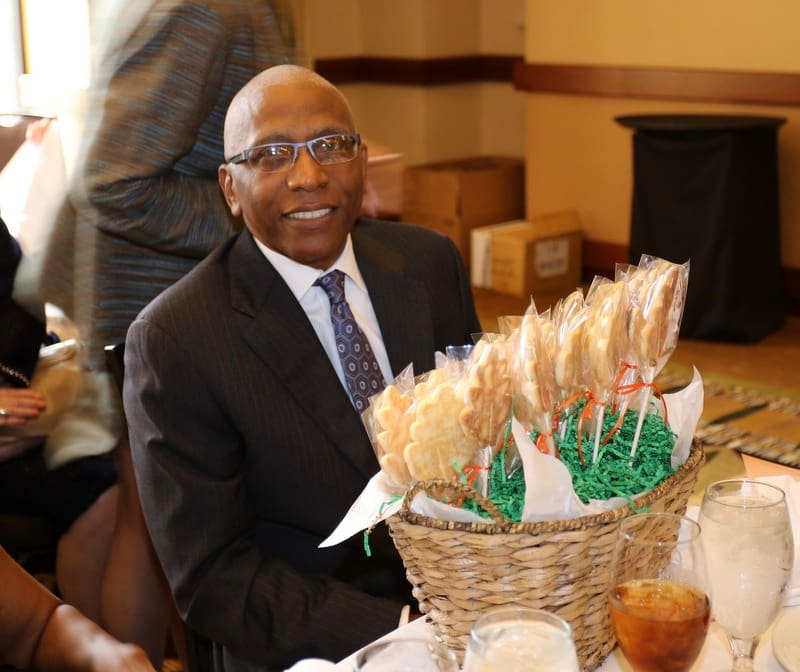 A man sitting at a table with a basket of cookies.