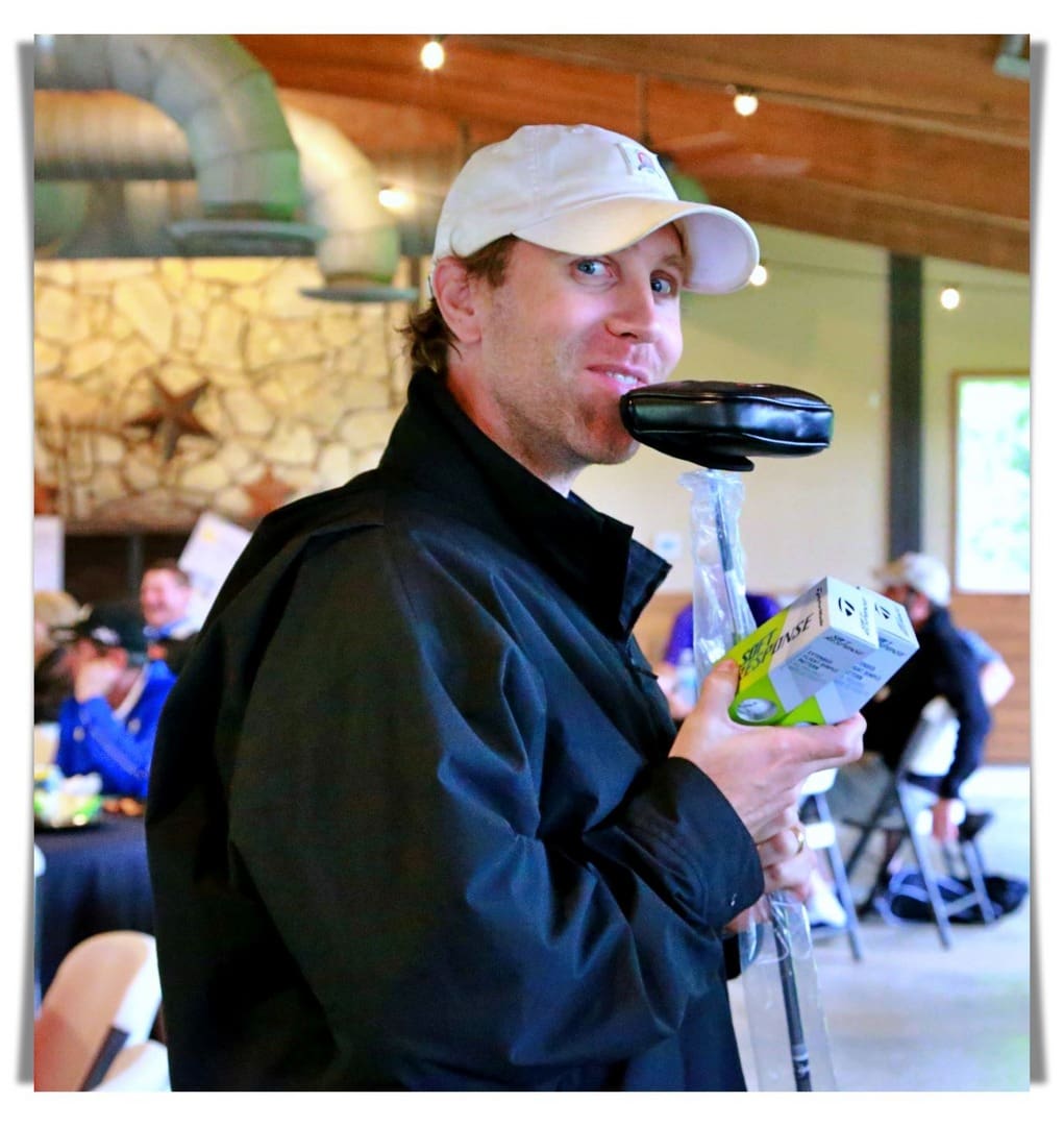 A man holding a golf club in his mouth.