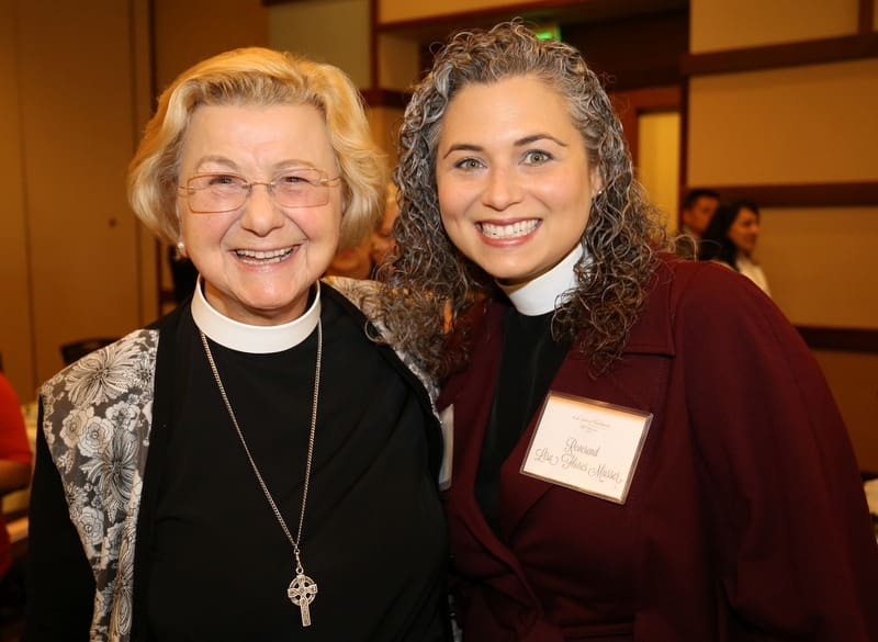 Two older women standing next to each other at an event.