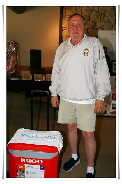 A man standing next to a cooler with a logo on it.