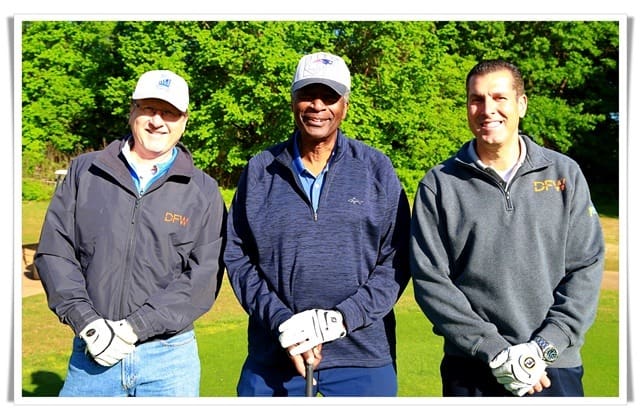 Three men posing for a picture on a golf course.