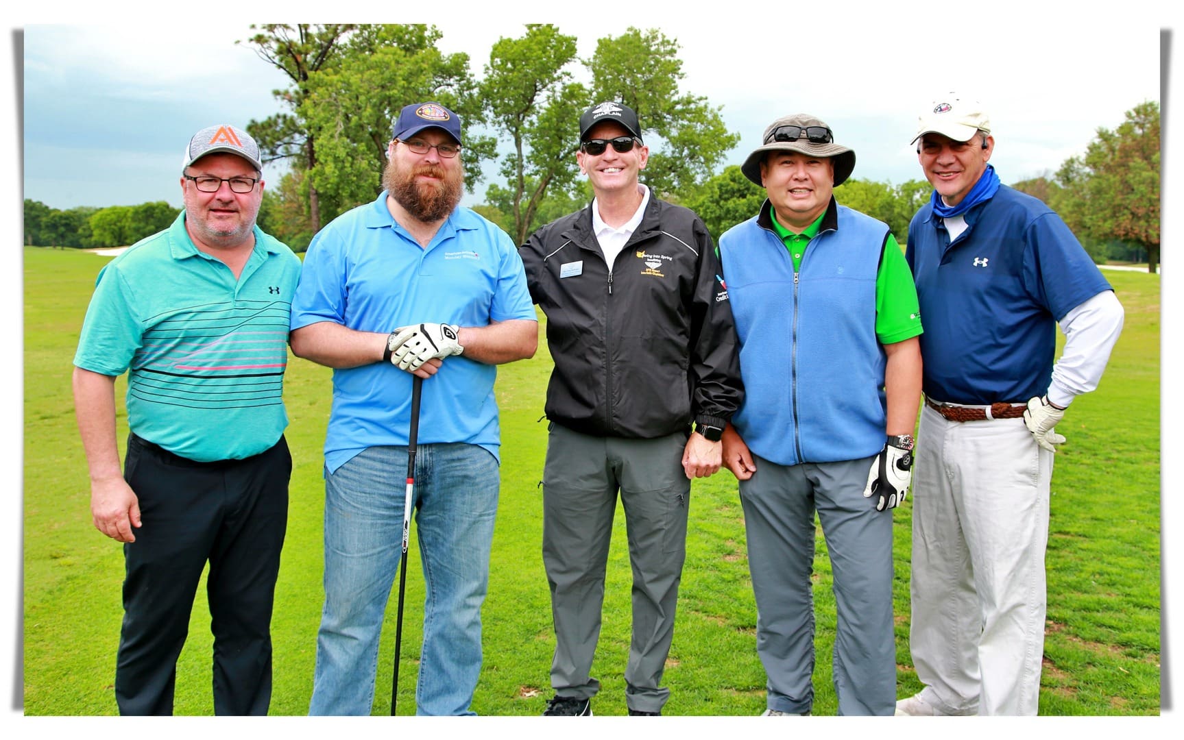 A group of men posing for a photo on a golf course.