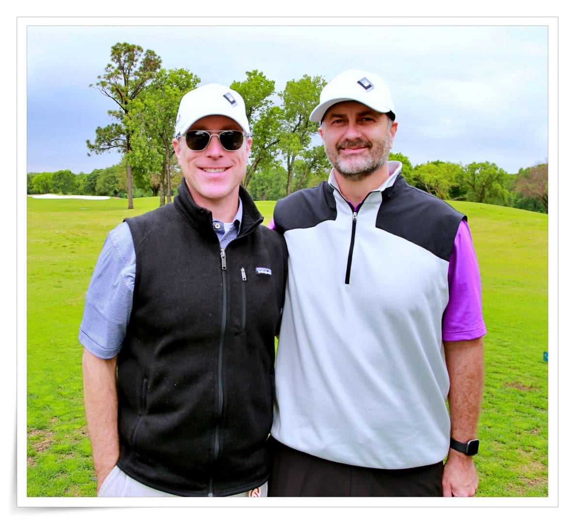 Two men posing for a photo on a golf course.