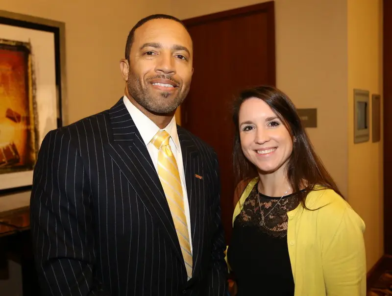 A man in a suit and a woman in a yellow shirt.