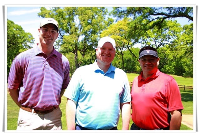 Three men posing for a picture on a golf course.