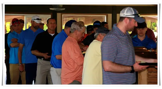A group of people standing in line at a golf tournament.
