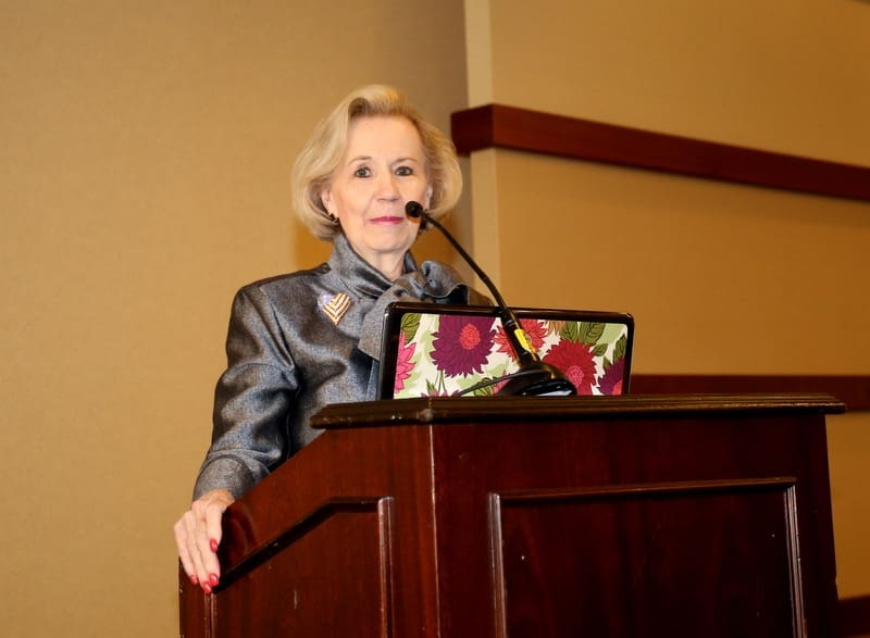 A woman giving a speech at a podium.