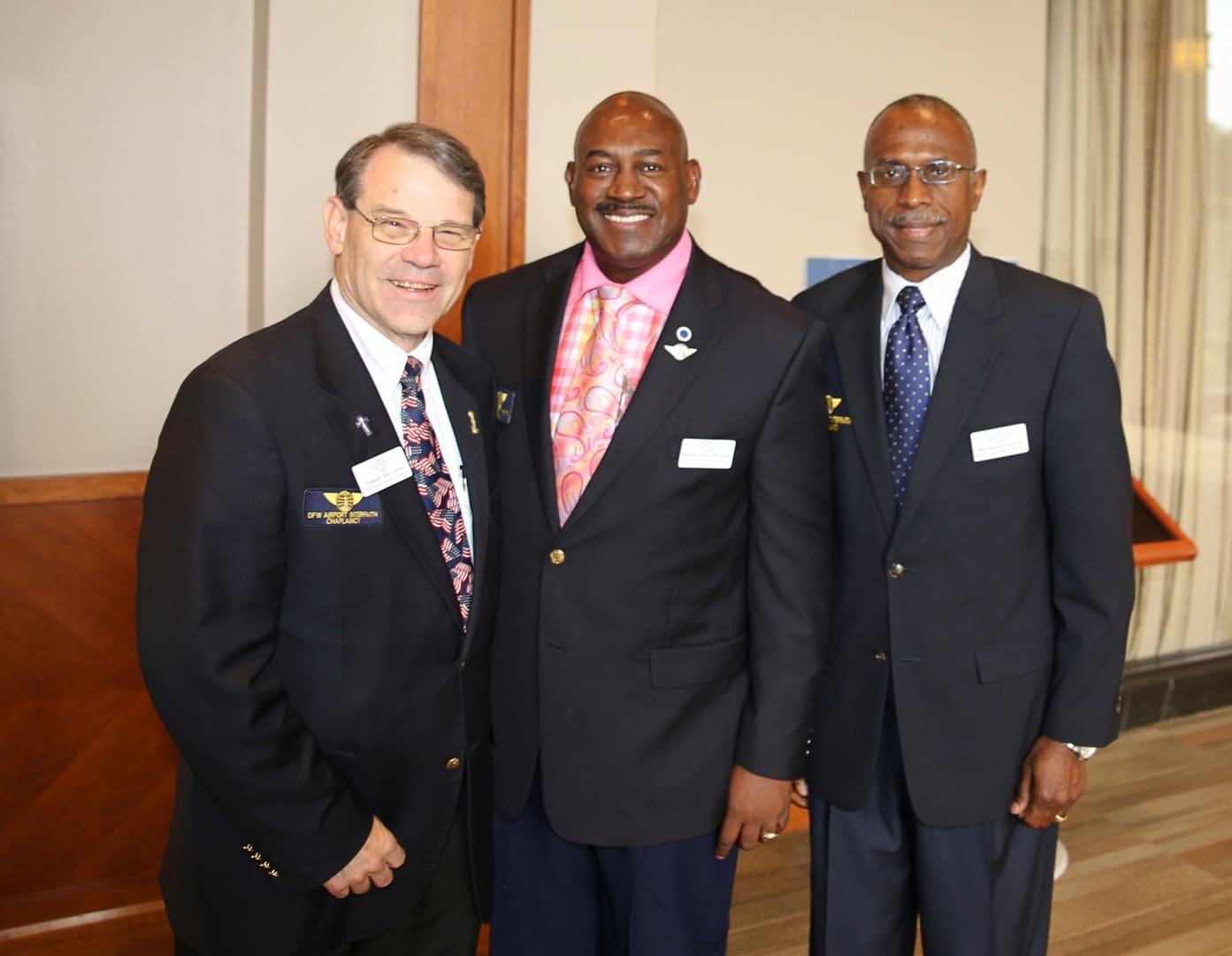 Three men in suits posing for a photo.