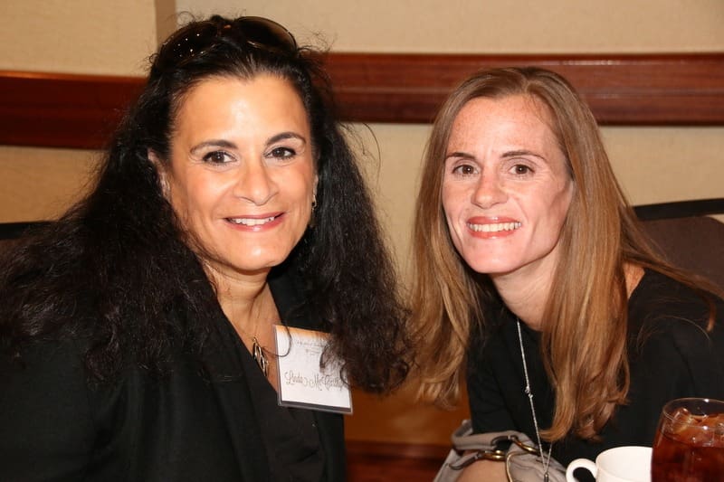 Two women posing for a photo at an event.