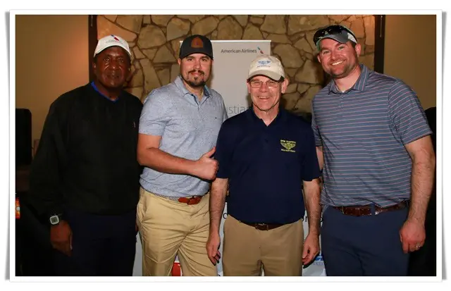 Four men posing for a photo at a golf tournament.
