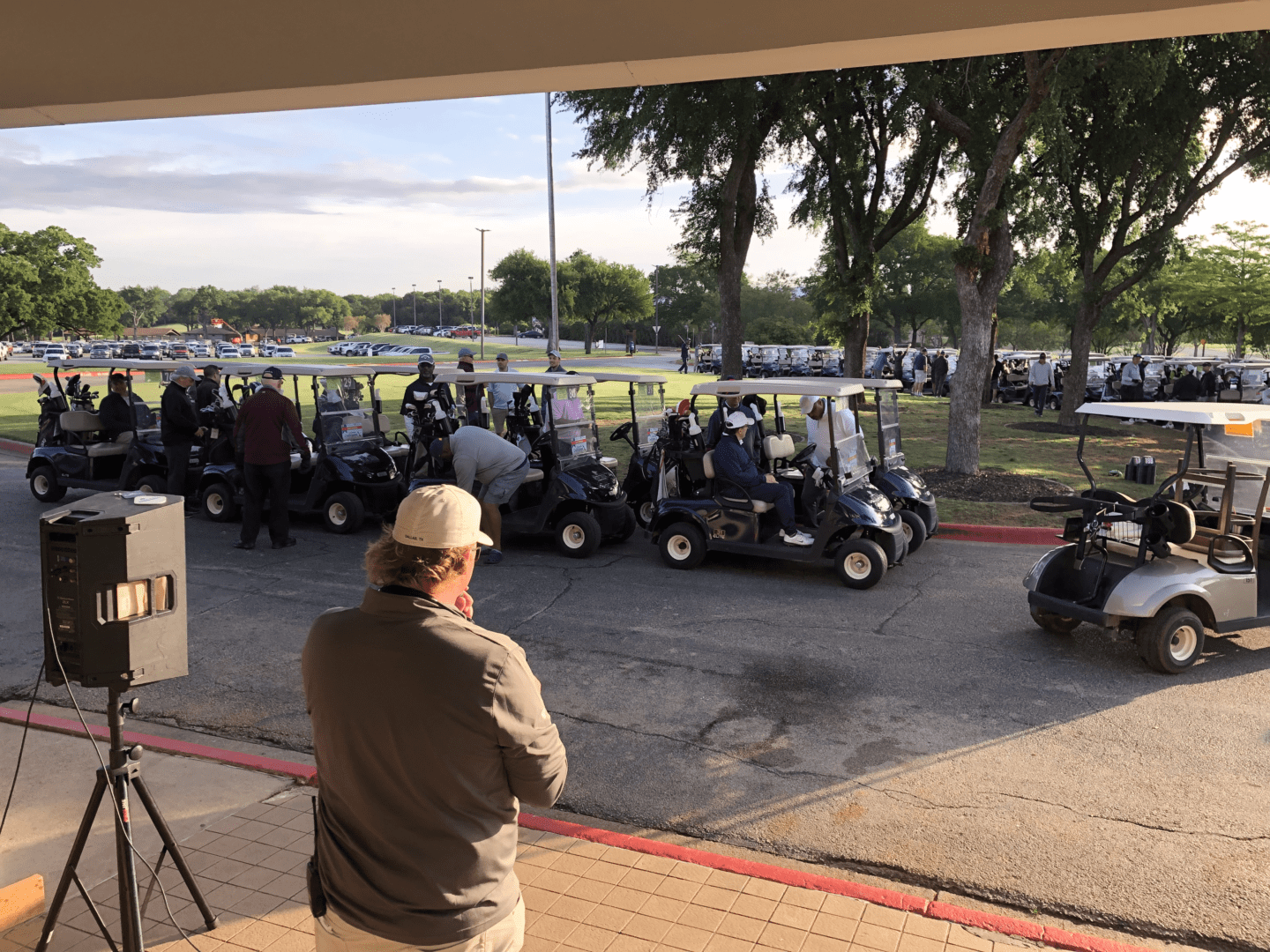 A man is standing in front of a group of golf carts.
