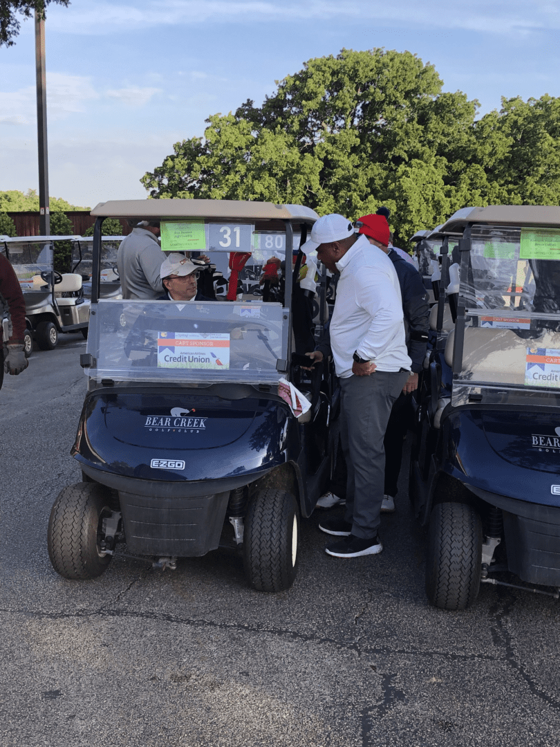 A group of golf carts parked in a parking lot.