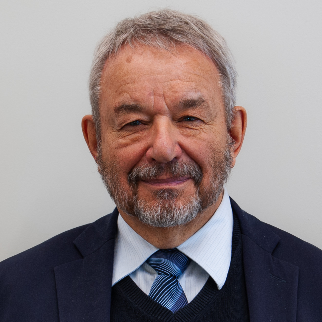 A smiling man in a suit and tie.