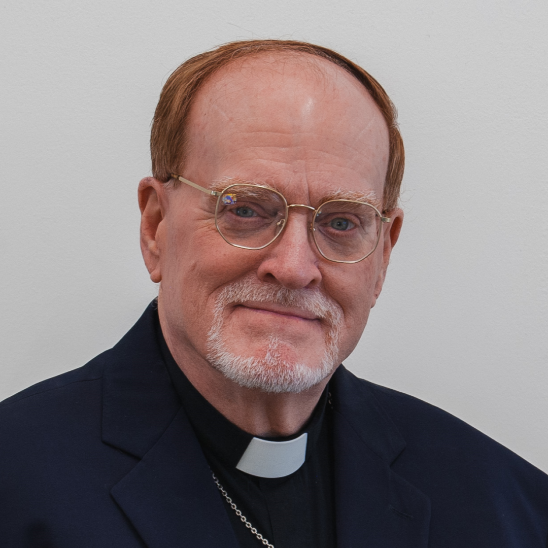 A man wearing glasses and a clerical collar.