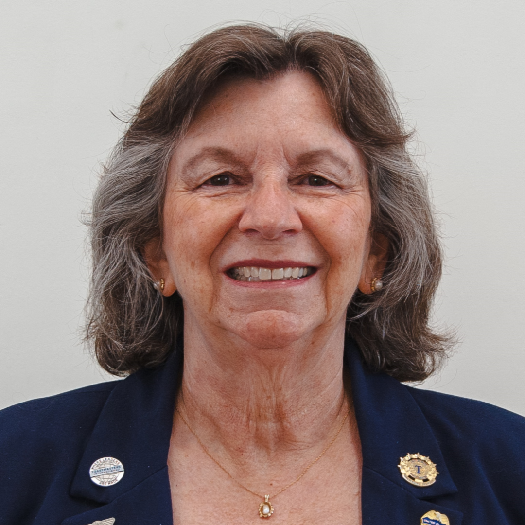 Smiling woman with gray hair and blue jacket.