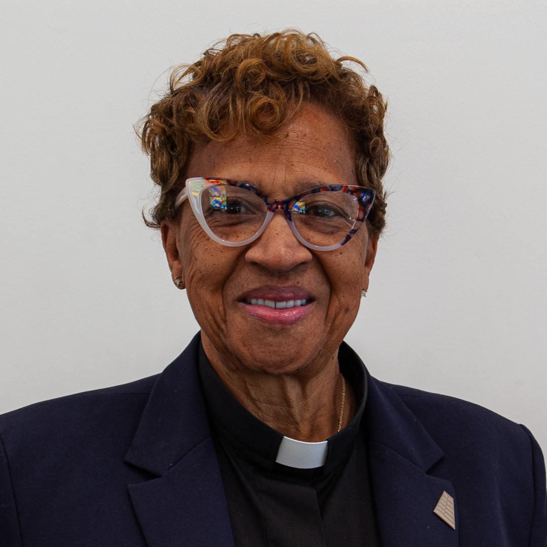 Smiling woman wearing glasses and a suit.